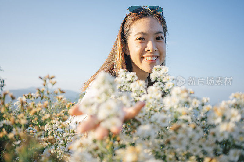 一位迷人的泰国/中国女性兴奋快乐地捕捉完美的日落时刻，她的追随者